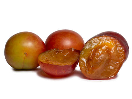 Cherry plum at different stages of maturation. Plum variety. Red and green fruits. Tkemali. Juicy fruit on the table. Compote ingredient.Close-upの写真素材