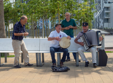 Batumi, Georgia. 06.21.2022 Street musicians on the bench. Bayanist at play. Men on vacation. street drummer. Making money with music and singingのeditorial素材