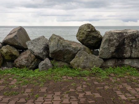 Barrier of large stones on the seashore. wave protection. Irregular stones. sea shore. viewの写真素材