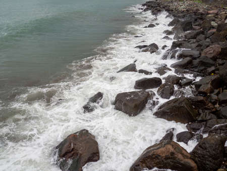 rocky seashore. The shore is fortified with huge stones. Large waves on the pier. Travel to Turkey. big waves. windy weatherの写真素材