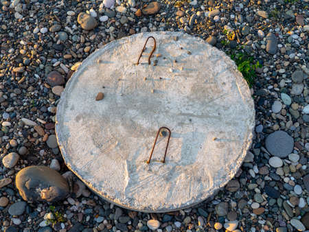 Concrete circle with hooks. Closed sewer hatch. safety. construction.の写真素材