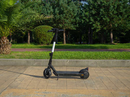 Electric scooter in the park. Abandoned transport. kick scooter. vacation at the resort. Leisure vehicleの写真素材