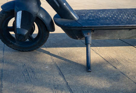 Part of an electric scooter close-up. Scooter on a footboard. Parking. Broken scooter wheel. Propulsion tool. Vehicles for funの写真素材