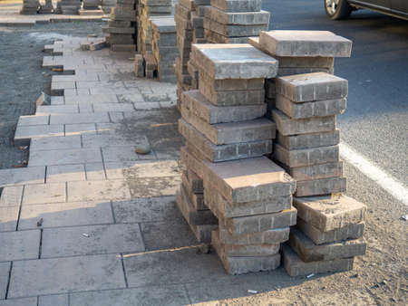 A stack of pavers tiles on the ground. road works. Laying tiles on the sidewalk. construction worksの写真素材