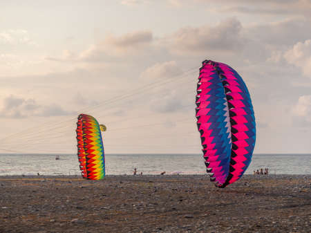 Parachutes on the ground. wind. kite festival. People fly kites. different kites in the sky. vacation at the resort.の写真素材