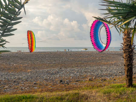 Parachutes on the ground. wind. kite festival. People fly kites. different kites in the sky. vacation at the resort.の写真素材