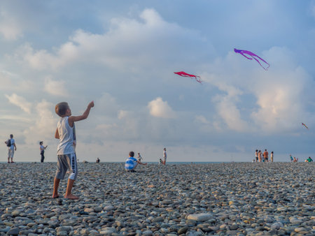 Batumi, Georgia. 08.13.2022 Lots of kites in the sky. Kite Festival. Colorful toys.  Beauty in the sky  boy launches a kite .Entertainment on vacation. Windy weatherのeditorial素材