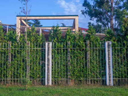 A fence made of rods and stacked stones. Zoo fence. stacked pebblesの写真素材