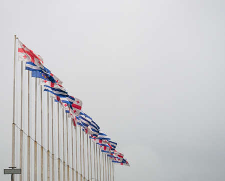 Lots of flags on flagpoles. Flags of Georgia and Adjara. state symbols. fluttering in the wind.の写真素材