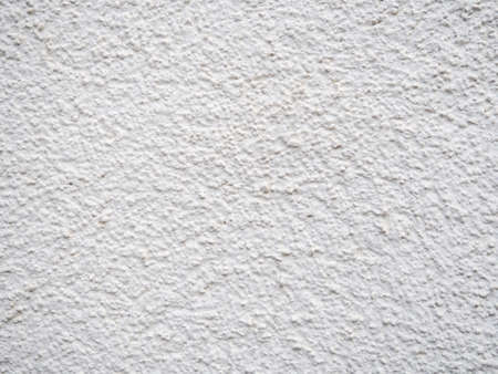 Background from solid material. Pimply white wall. Uneven wall surface. Painting in a light tone.の写真素材