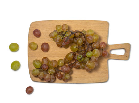Grapes on the table. white background. Kishmish on a white background. Grapes of different colors on a kitchen board. wine ingredient. Berriesの写真素材