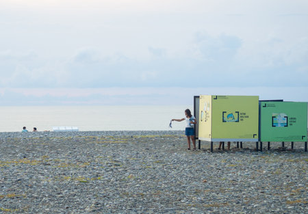 Batumi, Georgia. 09.07.2022   Pebble beach. Changing room by the sea. Modern beach. Summer time. A man in a dressing room on the beach.のeditorial素材