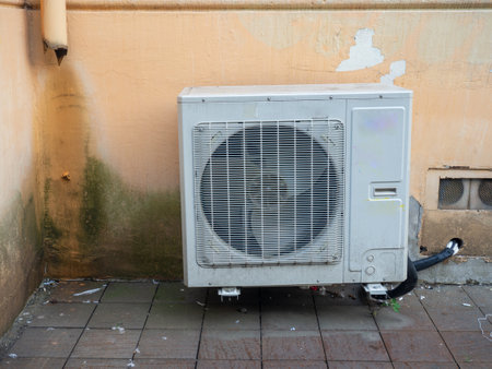 Old air conditioner on the corner of the house. Air conditioning among on the wall in a dirty street. Technique for climate control. urban environment.の写真素材