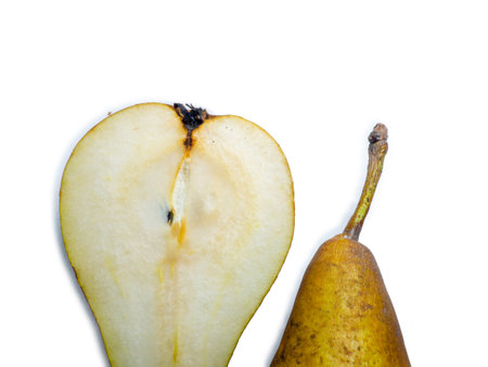 A pear cut in half. The pulp of a juicy fruit. Yellow pear on a white background. Food for a raw food lover. Delicious snack. fruit abundanceの写真素材