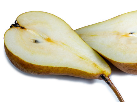 A pear cut in half. The pulp of a juicy fruit. Yellow pearl on a white background. Food for a raw food lover. Delicious snack. fruit abundanceの写真素材