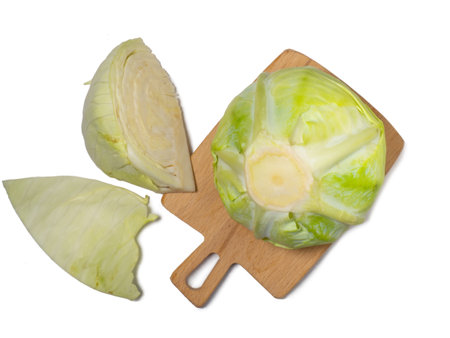 Pieces of white cabbage on a kitchen board on a white background. vegetable isolate. cut cabbage. Healthy lunch ingredient. Healthy food concept. borscht ingredientの写真素材