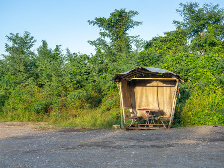 Old vintage gazebo by the road. Resting place for truckers. A bench covered with improvised material for gatherings.の写真素材