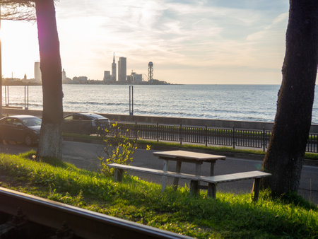 Seats with a table against the backdrop of the sea and the city. Nice place to eat. Sunset over the city. Cozy placeの写真素材