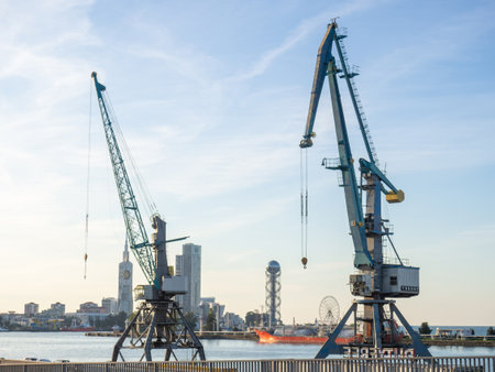 Cranes of the seaport against the backdrop of the city. lifting mechanism. maritime industry. Cargo shipping. Cranes on the sea.の写真素材