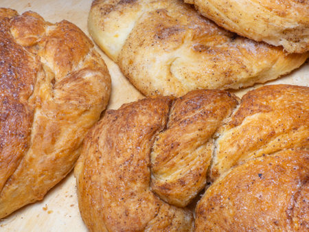 Wicker bun with cinnamon and sugar. Bread product of an unusual shape. homemade baking. Buns with a ruddy crust. Closeup of foodの写真素材
