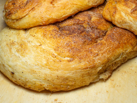 Wicker bun with cinnamon and sugar. Bread product of an unusual shape. homemade baking. Buns with a ruddy crust. Closeup of foodの写真素材