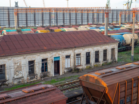 Old abandoned station building. Creepy places. Sunset at the train station. The cargo part of the station is an industrial zone against the backdrop of mountains. Fuel wagons. Cargo transportationのeditorial素材