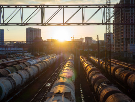 Batumi, Georgia. 10.18.2022 Tanks with fuel on the railway tracks at sunset. Sunset at the train station. The cargo part of the station is an industrial zone against the backdrop of mountains. fuel wagons. Cargo transportationのeditorial素材