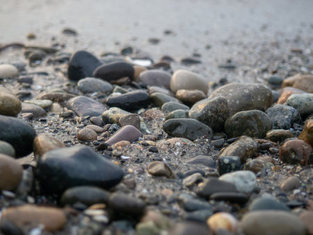 Pebbles on the seashore close-up. rocky beach. Stones close-up with bokeh. gray natural background. The concept of rest on the seashore. The Velvet season. Autumn on the coast. Waves and wet pebblesの写真素材
