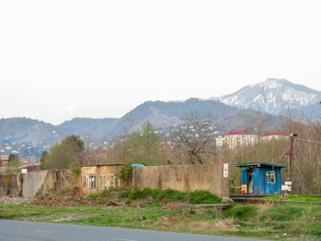 Old wall against the backdrop of mountains. Abandoned places. Forgotten infrastructure. Broken houses. Guard boothの写真素材