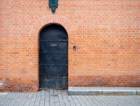 Powerful door in a brick wall. old red brickwork. Kremlin wall. iron door. historical place. architectural monumentの写真素材