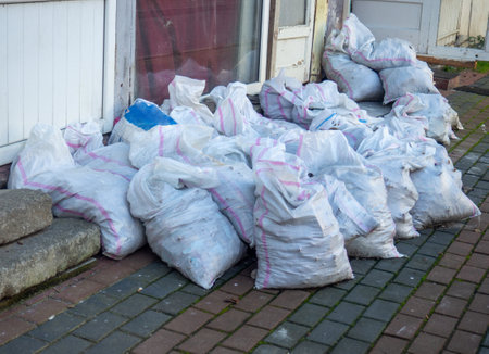 Bags with construction debris on the street. Lots of white bags. Preparing garbage for pickup. construction wasteの写真素材