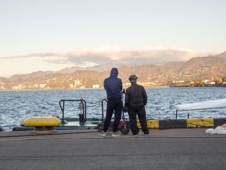People on the pier by the sea. At the seaport. Hobbies and recreation. fishing people. Quiet type of holidayの写真素材
