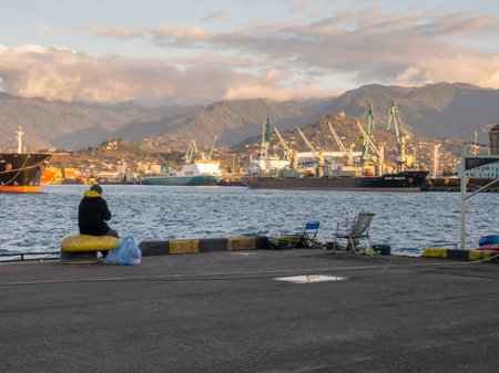 People on the pier by the sea. At the seaport. Hobbies and recreation. fishing people. Quiet type of holidayの写真素材