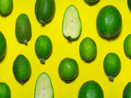 Feijoa on a yellow background. Green fruit on yellow. Feijoa background. Useful sour fruit. brightlyの写真素材