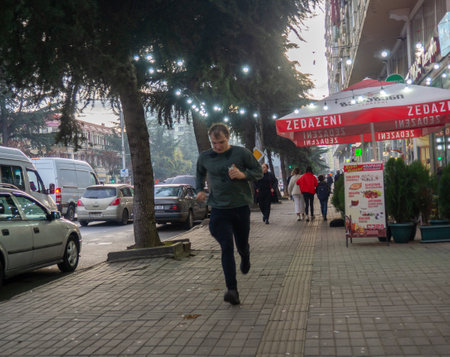 Batumi, Georgia. 21/11/2022 A man runs down the street. man in the city. Pedestrian zone. Man in a hurryのeditorial素材