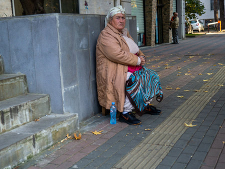 Batumi, Georgia. 11.23.2022 Street scene. people on the street. urban environment. Sidewalk with pedestrians. People's life. Beggar asks for moneyのeditorial素材