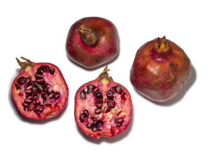 Sliced pomegranate on a white background. Juicy fruit with seeds. Pieces of red fruit. Juicy pulp. pomegranate isolate. Juice ingredient. Vegetarianismの写真素材