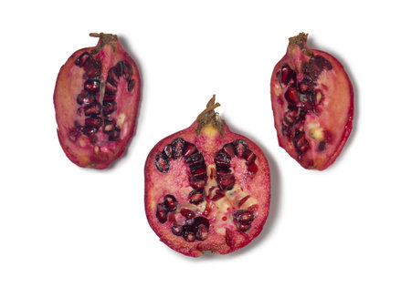 Sliced pomegranate on a white background. Juicy fruit with seeds. Pieces of red fruit. Juicy pulp. pomegranate isolate. Juice ingredient. Vegetarianismの写真素材