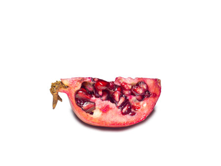 Sliced pomegranate on a white background. Juicy fruit with seeds. Pieces of red fruit. Juicy pulp. pomegranate isolate. Juice ingredient. Vegetarianismの写真素材