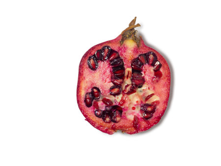 Sliced pomegranate on a white background. Juicy fruit with seeds. Pieces of red fruit. Juicy pulp. pomegranate isolate. Juice ingredient. Vegetarianismの写真素材