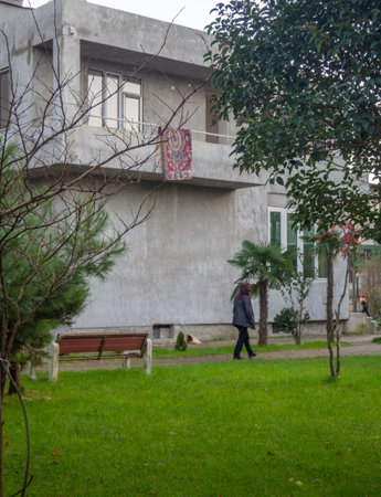 a woman walks down the street.City environment. Asian city streets. cozy yard. winter in the south. carpet on the balconyの写真素材