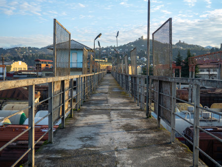 The old bridge over the railway cars leading to the mountains. Rusty metal structure. Pedestrian bridge in the industrial area.の写真素材