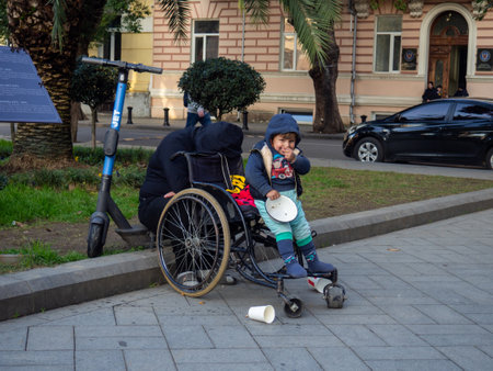 Batumi, Georgia. 12.18.2022 Beggars with a child in a jar on the street. Poor people. need help. Streets of Btumi. child begging for almsのeditorial素材