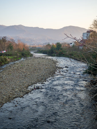 A shallow fast river. Stream with shallows. Fast river in the city. Concrete rapids on the river. River in Georgia. Surroundings of Batumiの写真素材