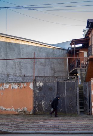 Batumi, Georgia. 01.10.2023  beggar woman walks against the wall. Local resident in the old area. The household. The courtyard is old in Batumi.のeditorial素材
