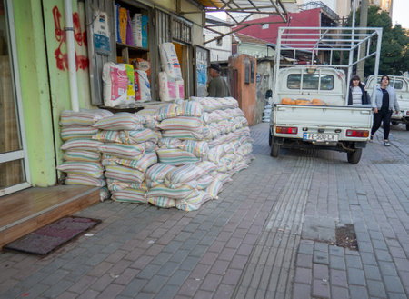 Batumi, Georgia. 01.18.2023 Bags of building material stacked on top of each other against the wall. Store goods on the street. Market Street. Bags of cementのeditorial素材