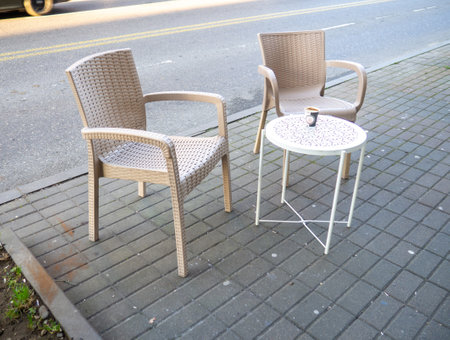 Empty table with two chairs in a street cafe. Free space at the diner. The coffee is cold on the table. Plastic furniture in a cafeの写真素材