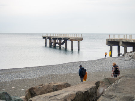 People are walking along the pier. Cold season at the resort. Not a season. broken pierの写真素材