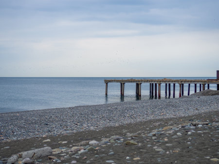 An old pier protruding into the water. Sea coast. Old pier. Not already in useの写真素材