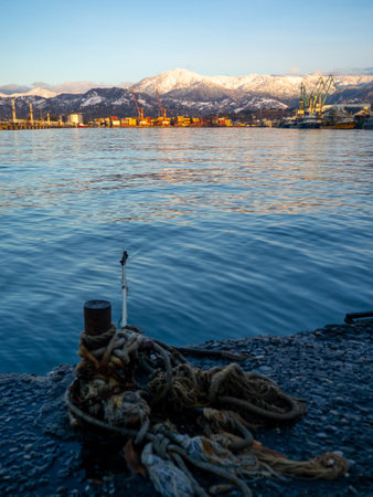 rope goes into the water from the bollard. Attaching boats to the pier. Port area. Sea port. A taut rope.の写真素材